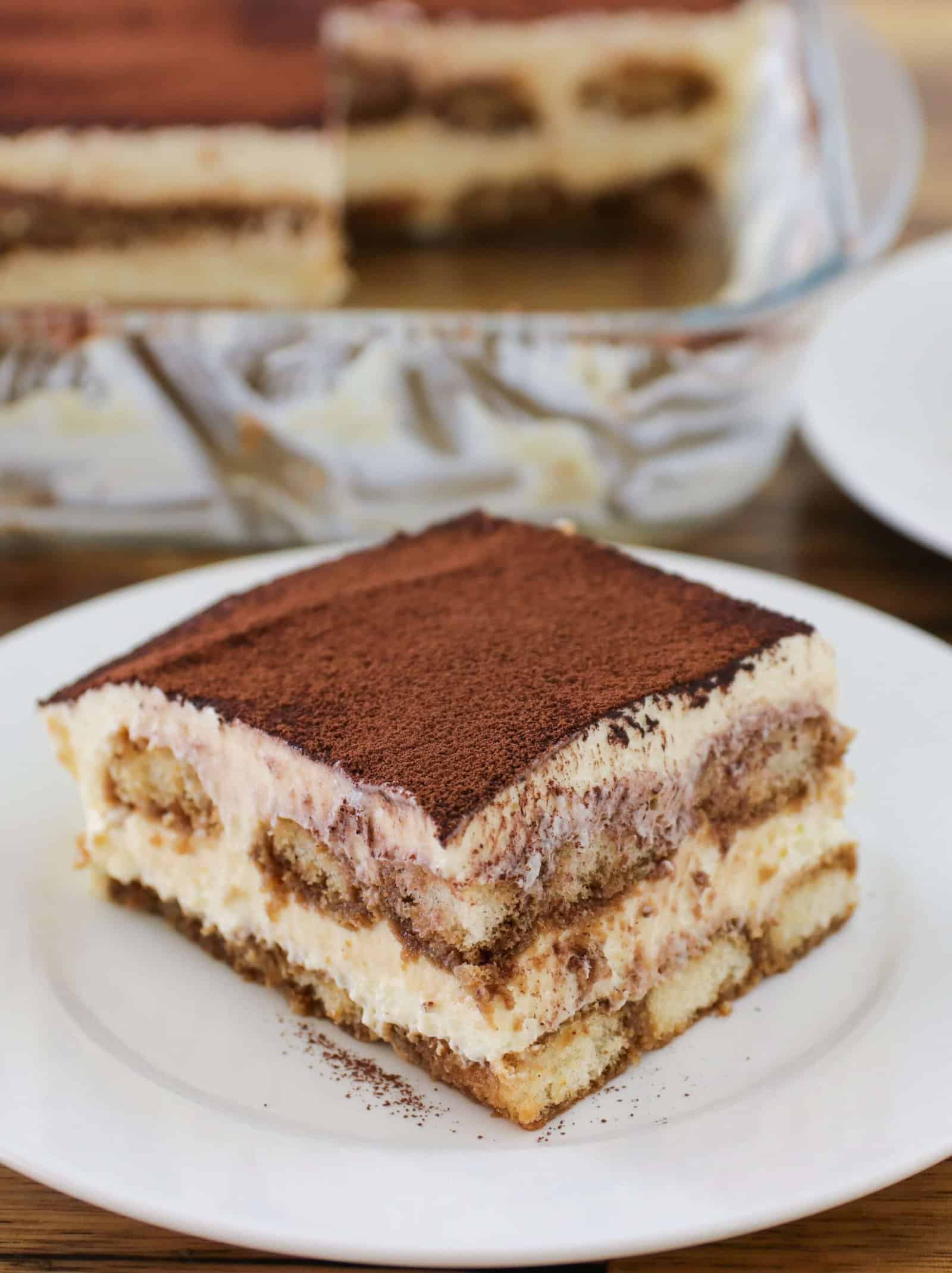 a slice of classic italian tiramisu laying on a white plate