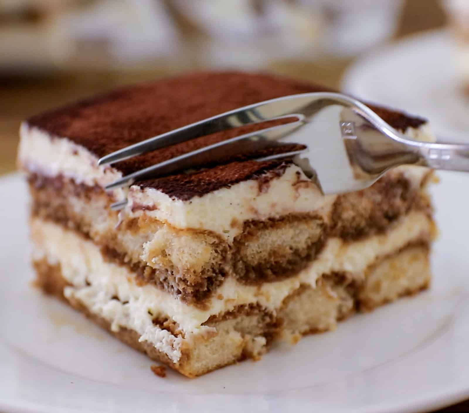 a fork going into a creamy tiramisu slice