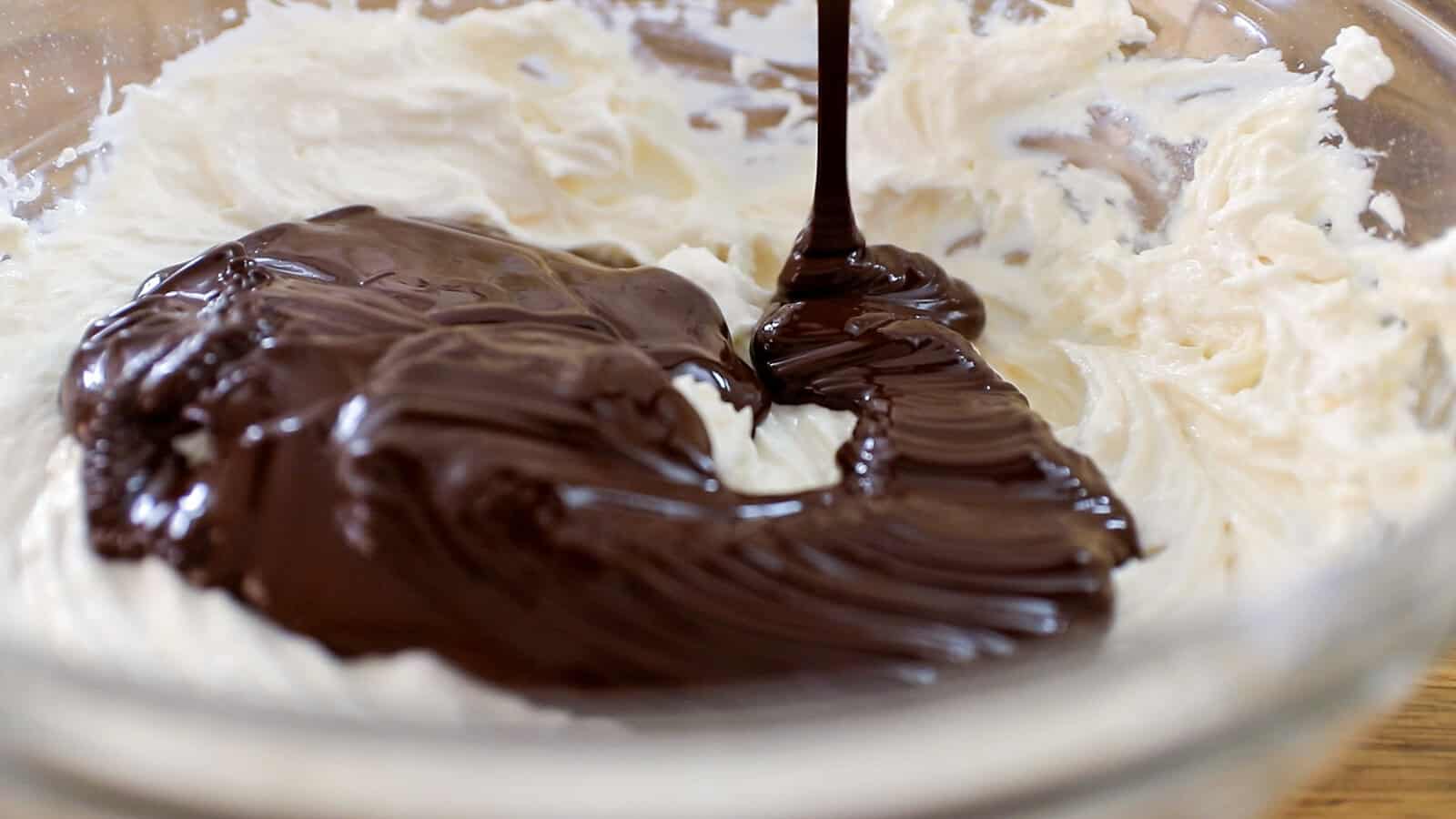 adding melted dark chocolate to a cheesecake filling