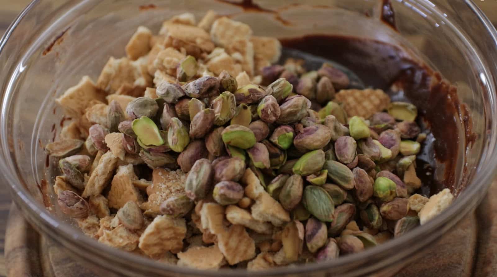 Stir in the crushed biscuits, toasted pistachios, and a pinch of salt to create a rich and flavorful mixture