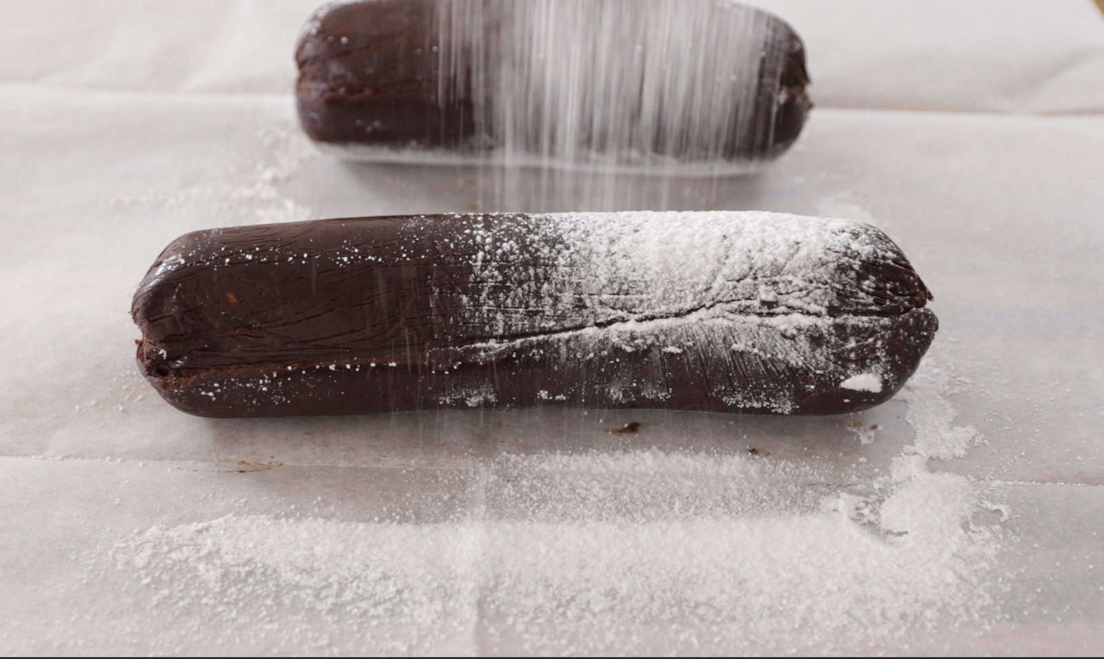 Dust the log with powdered sugar and wrap in twine to give it the authentic salami look before slicing and serving.