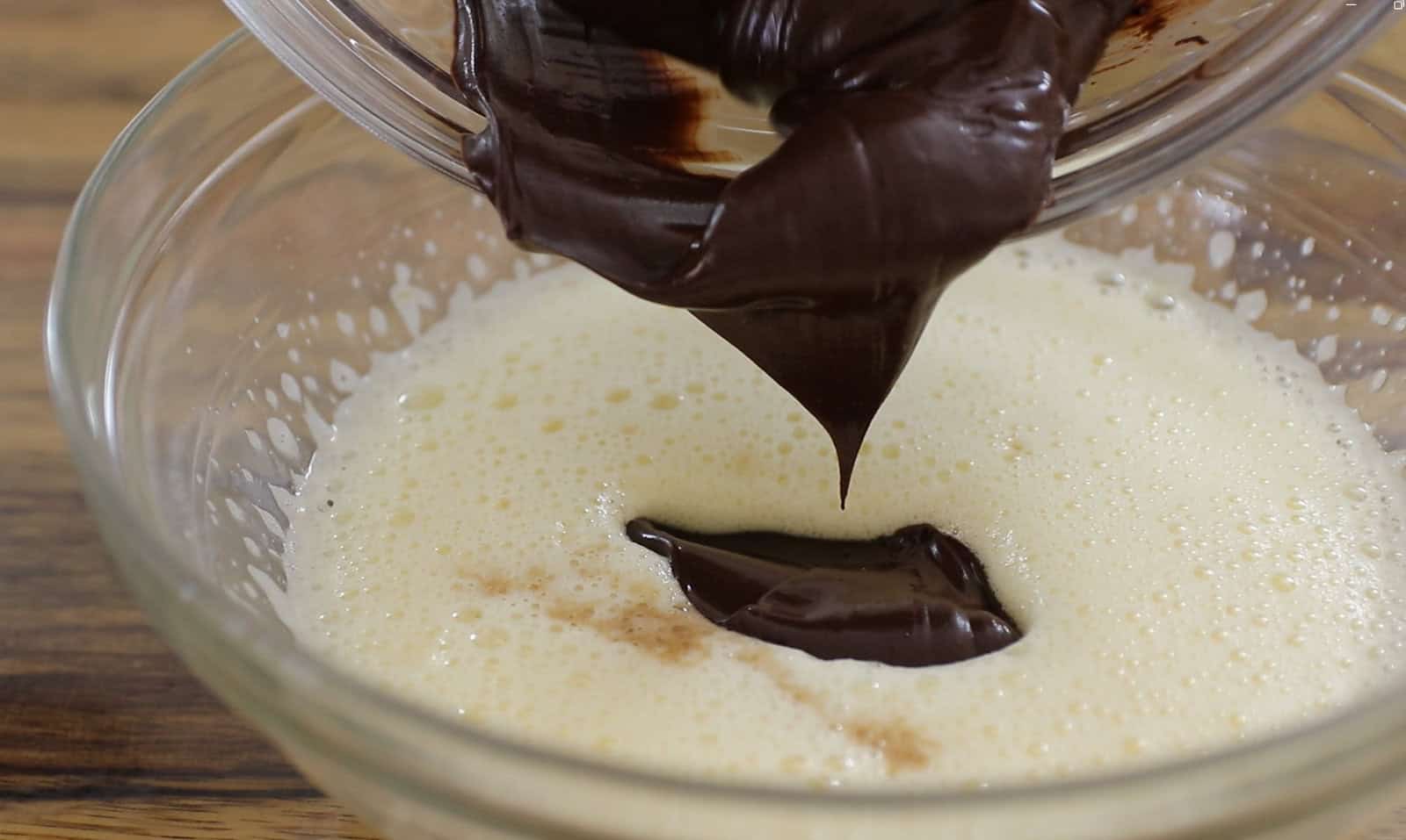 Add melted chocolate, and vanilla extract and sift in cocoa powder, flour, and baking powder.