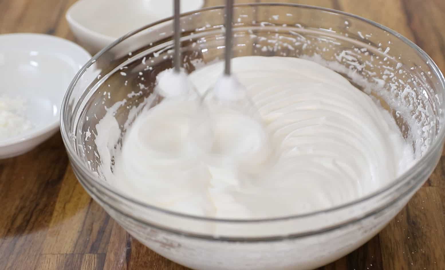 Whisk egg whites until stiff peaks form, gradually adding caster sugar for glossy perfection