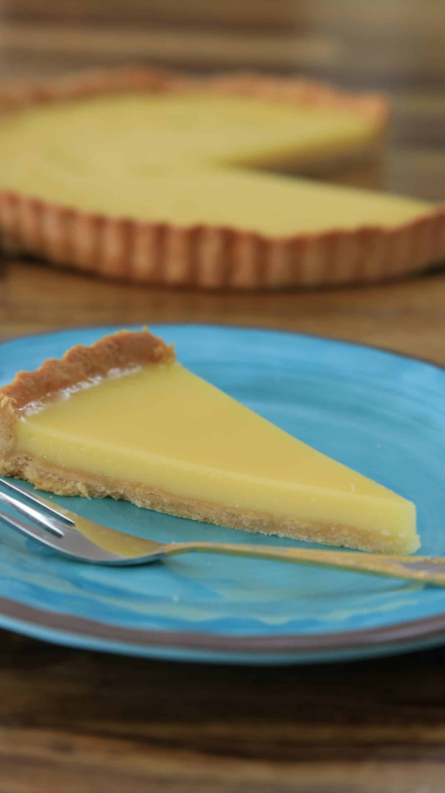 a slice of lemon tart on a blue plate