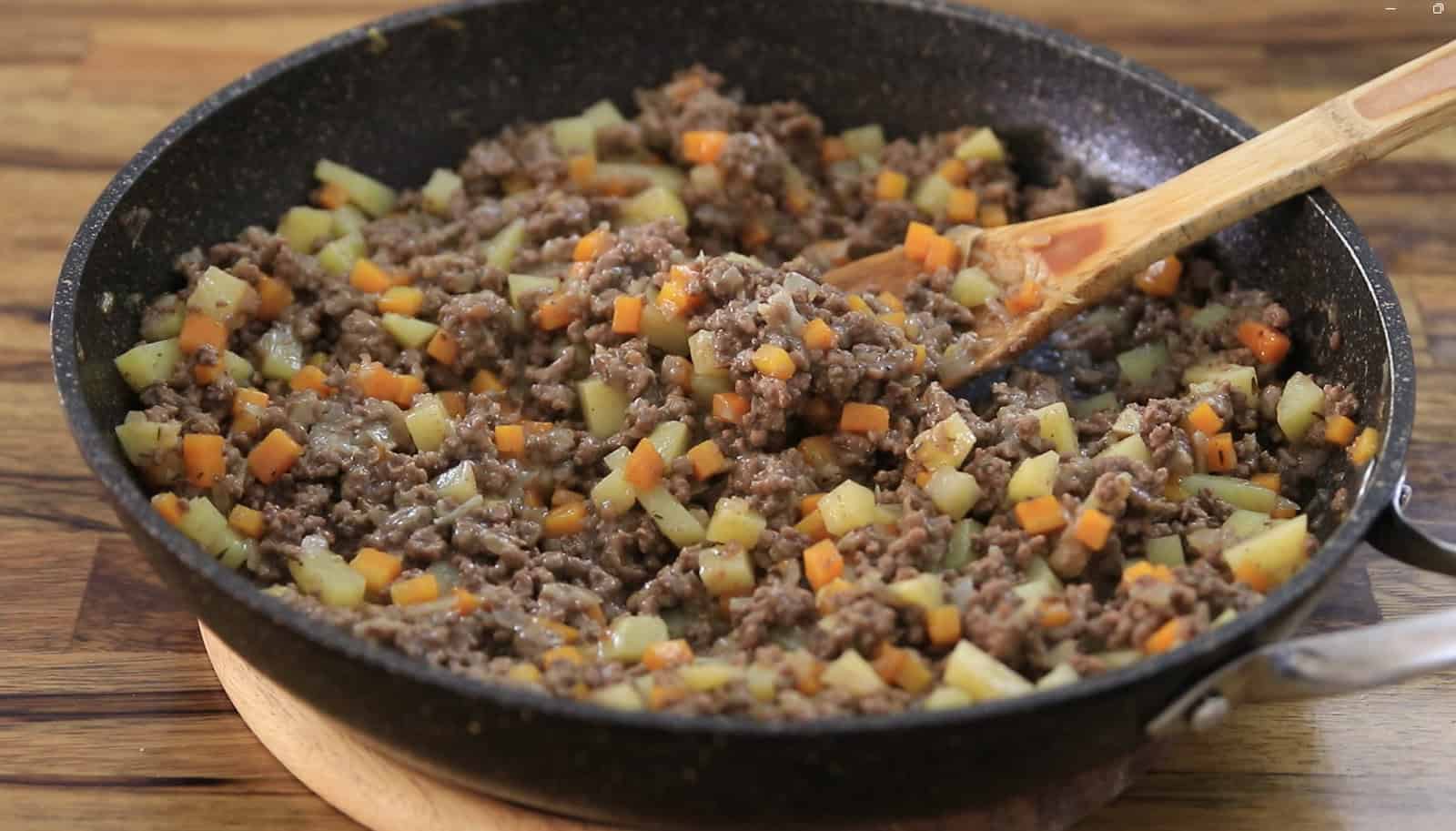 Cook the Filling: Sauté onions, carrots, and ground beef. Add potatoes, thyme, and seasonings for a hearty, flavorful filling. Simmer until thickened.