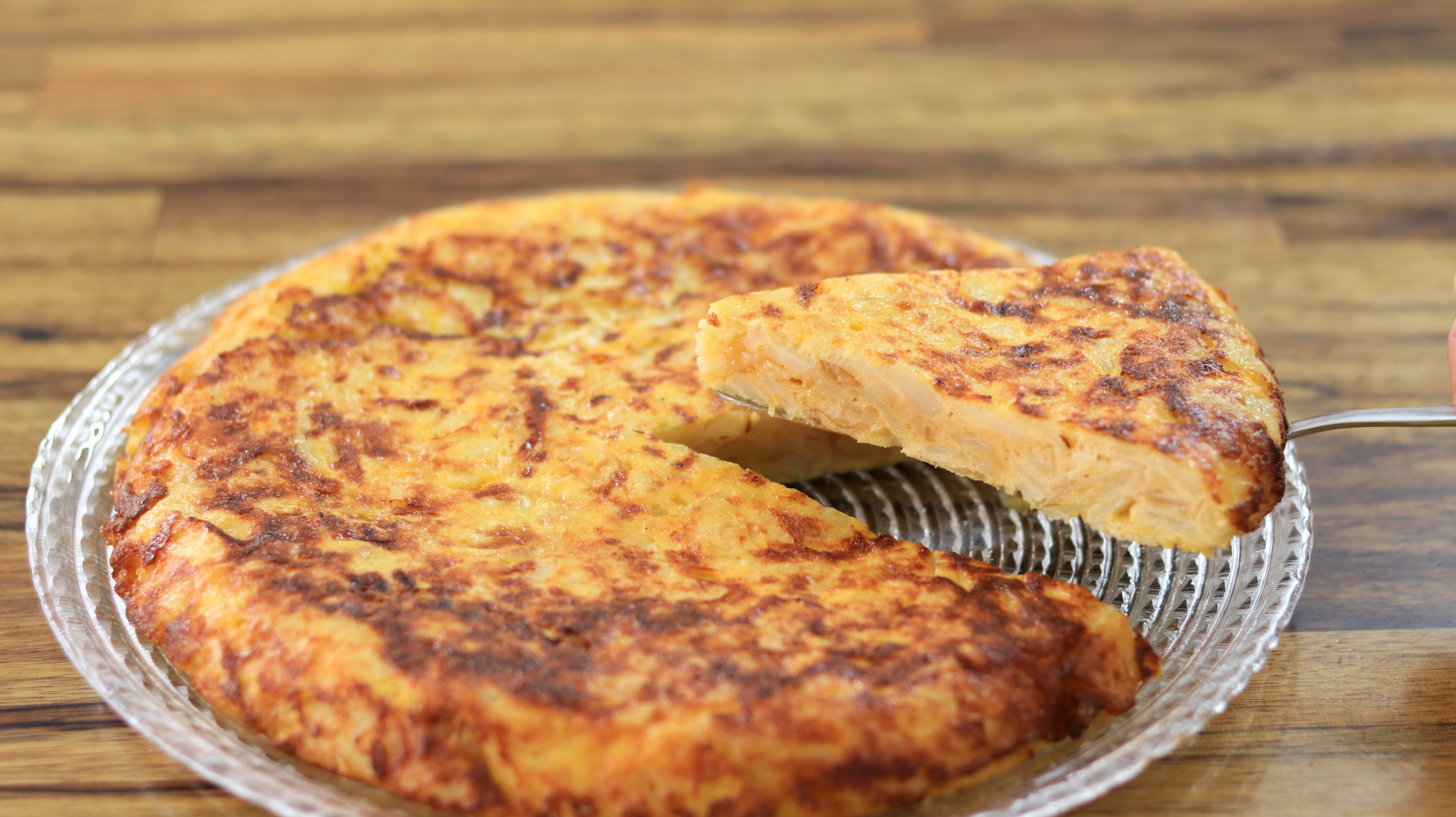 a slice of tortilla de patatas being lifted from the plate