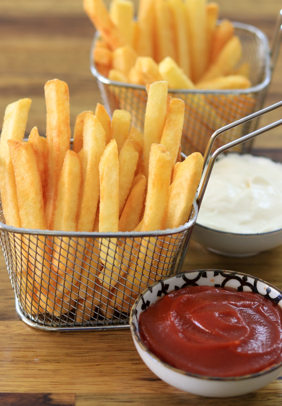 Homemade crispy French fries in a mentel basket