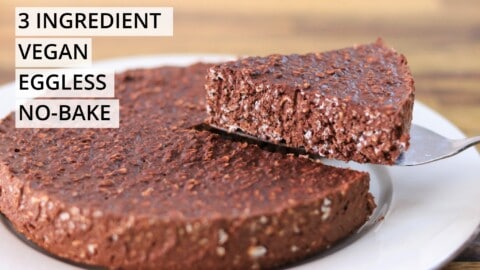 A slice of a chocolate cake is being lifted from a full cake on a white plate. The image has overlaid text that reads "3 INGREDIENT VEGAN EGGLESS NO-BAKE.