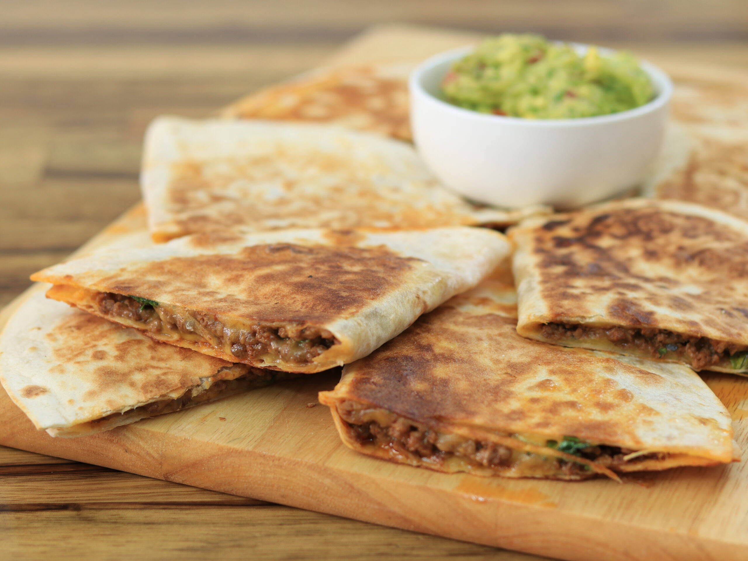 cheesy ground beef Quesadillas on a cutting board