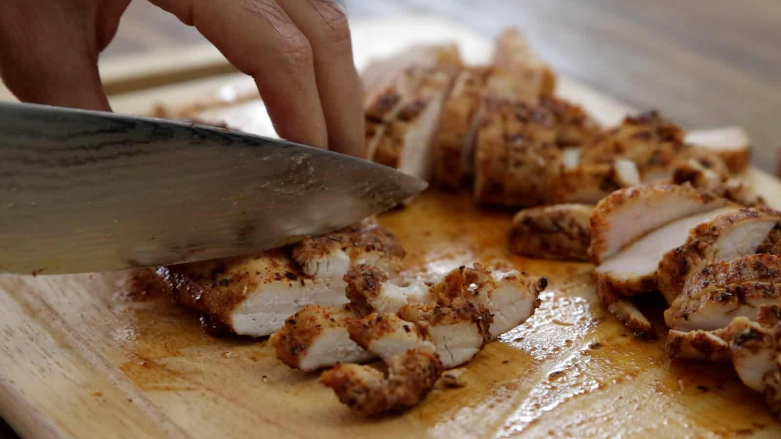 chopping grilled chicken breast for salad