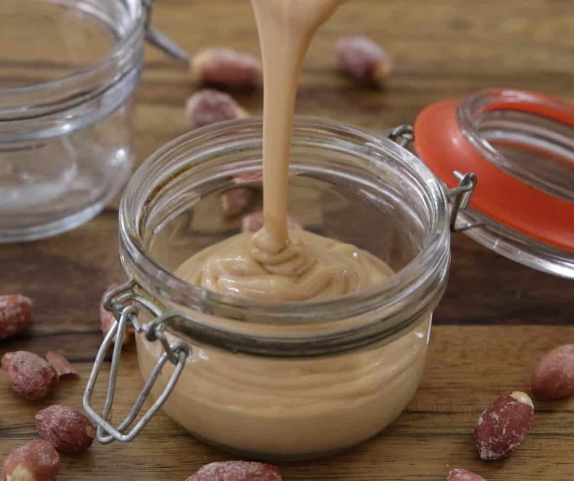 homemade peanut butter is poured into mason jar