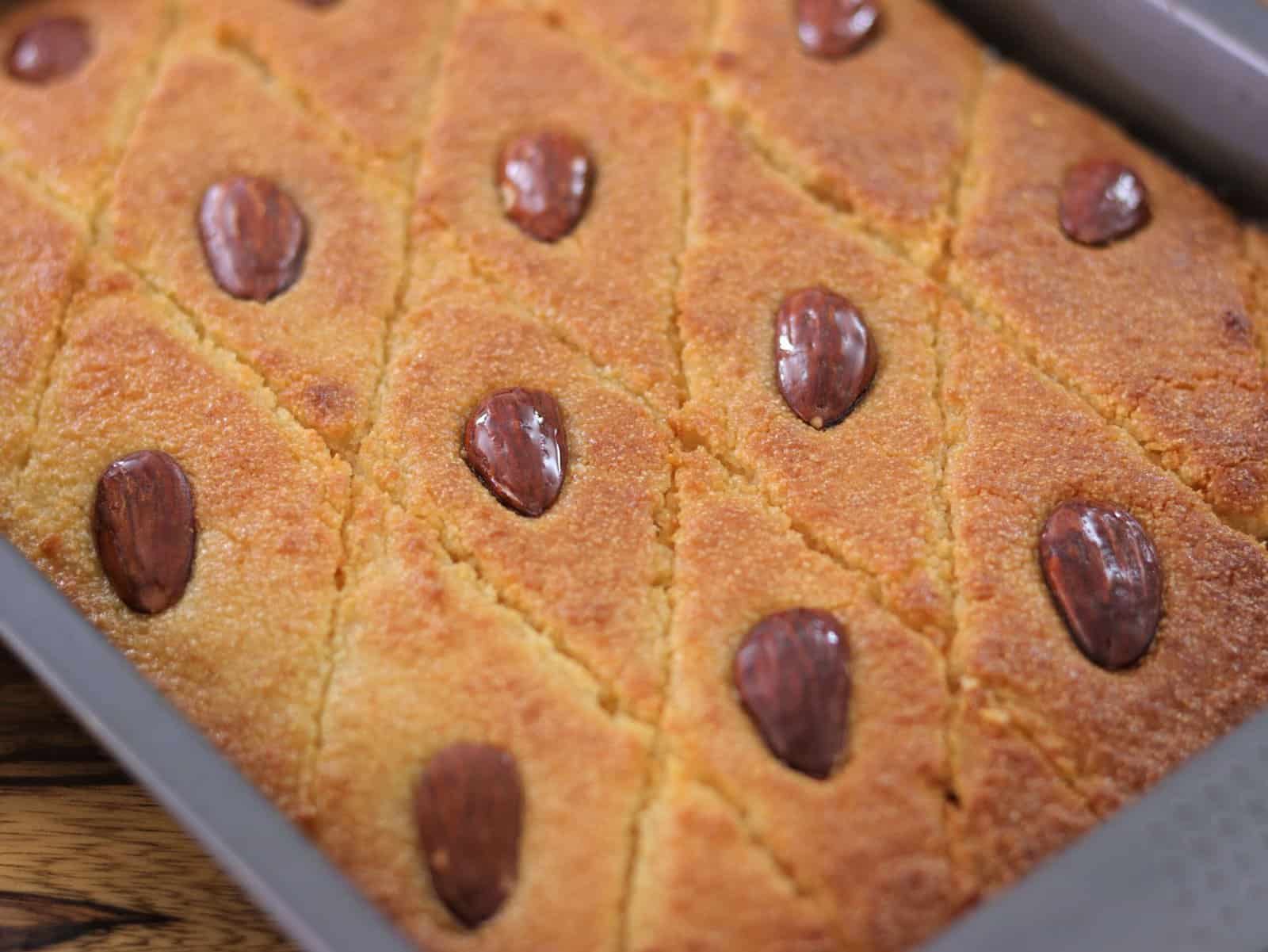 a shiny and moist basbousa cake topped with almonds