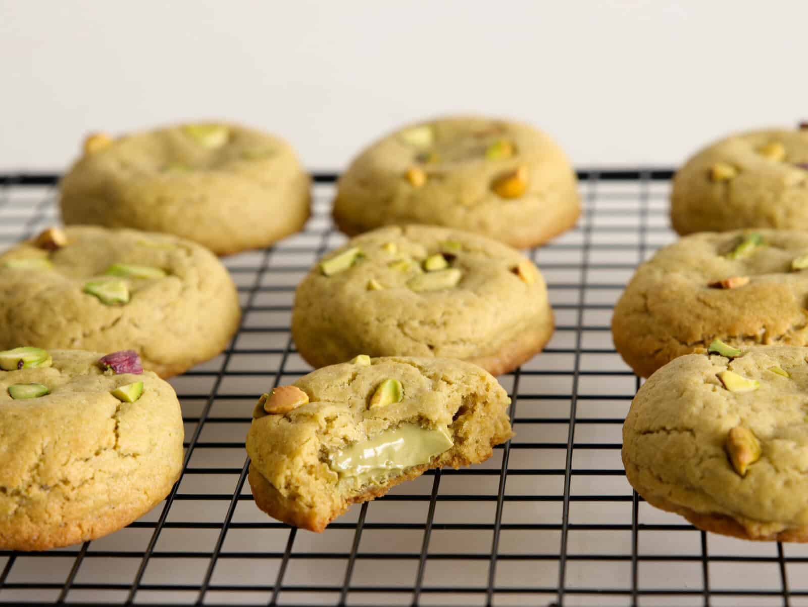 pistachio cookies stuffed with pistachio cream on a wire rack