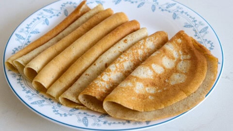 oatmeal crepes. The left image displays a plate of several neatly folded crepes, while the right image features a close-up of a hand holding two folded crepes. The words "OATMEAL CREPES" are prominently displayed at the top of the image.