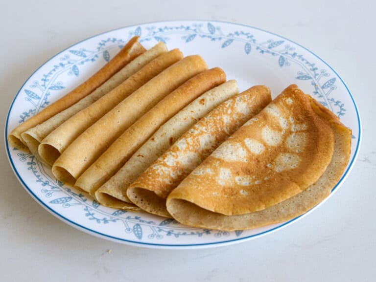 oatmeal crepes. The left image displays a plate of several neatly folded crepes, while the right image features a close-up of a hand holding two folded crepes. The words "OATMEAL CREPES" are prominently displayed at the top of the image.