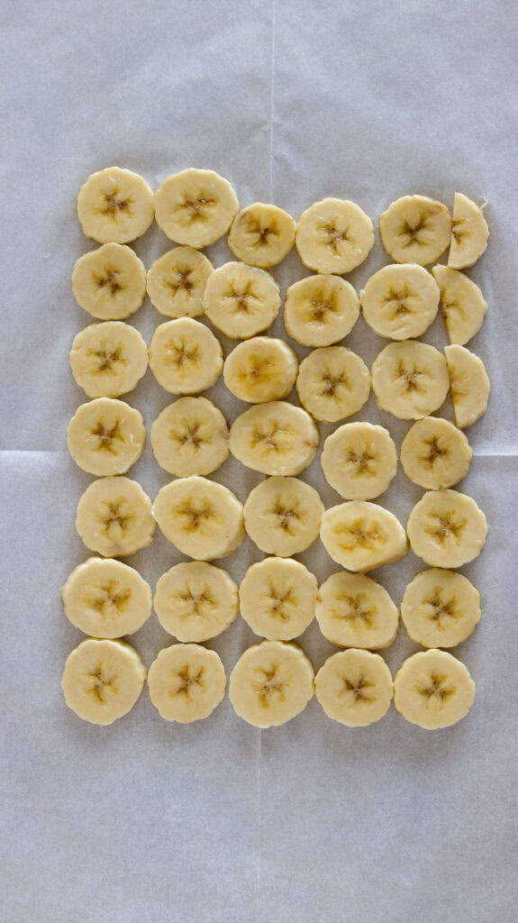 a layer of sliced bananas on a parchment paper