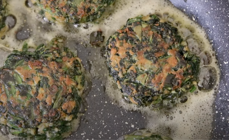 spinach patties are being fried in a pan with olive oil