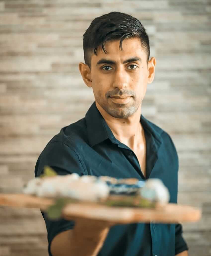 Picture of David in a blue shirt holding wood on a platter.