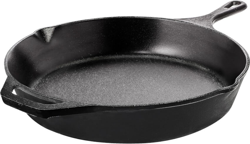 A black cast iron skillet with a handle and a pour spout on one side is displayed against a white background. The skillet has a slightly textured surface and a shallow depth, typical for frying and cooking versatile dishes.