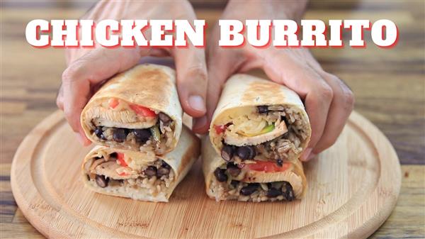 A close-up of two hands holding two halves of a chicken burrito on a wooden cutting board. The burrito contains rice, black beans, chicken, and vegetables. The text "CHICKEN BURRITO" appears prominently at the top of the image.