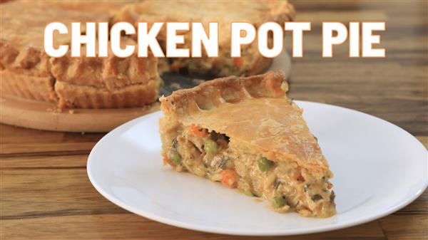 A slice of chicken pot pie is served on a white plate in the foreground, with the rest of the pie on a wooden board in the background. The pie has a golden-brown crust, and the filling appears to contain chicken and mixed vegetables. The text "CHICKEN POT PIE" is prominently displayed.