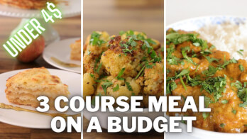 A promotional image showing a three-course meal on a budget. The text "UNDER 4$" and "3 COURSE MEAL ON A BUDGET" is displayed. The meal includes an apple and cake appetizer, a main dish of herbed potatoes, and a curry served with rice, all garnished with fresh herbs.