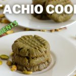 A stack of pistachio cookies sits on a white plate with scattered pistachios nearby. Another plate with a stack of cookies is in the background. The text "PISTACHIO COOKIES" and "4-INGREDIENTS" is overlaid on the image.