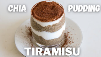 A layered chia pudding tiramisu dessert in a glass cup, topped with cocoa powder, sits on a white plate. The words "CHIA PUDDING TIRAMISU" are displayed around the dessert.