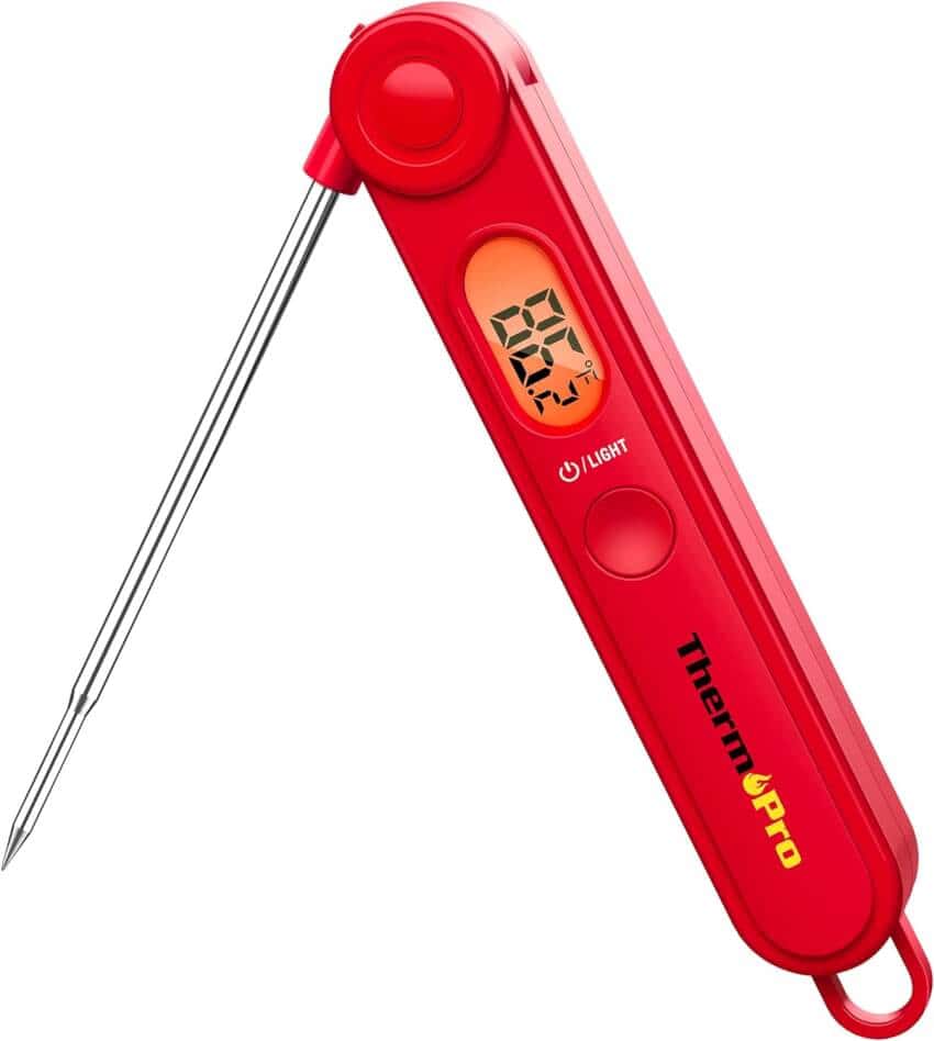 A digital meat thermometer featuring a red body with a metallic probe. The device shows a temperature reading on a small LCD screen and includes buttons for features like a backlight. The brand name "ThermoPro" is displayed on the front of the thermometer.