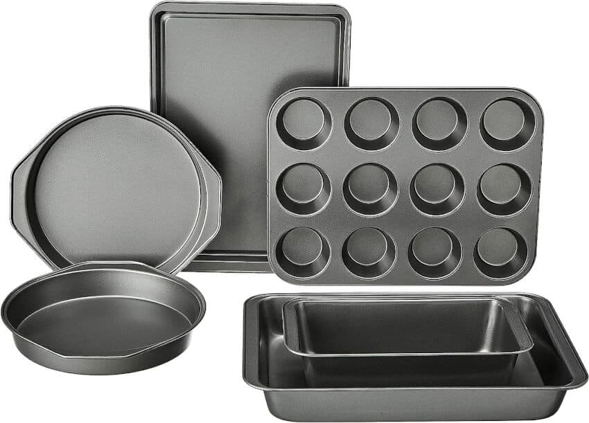 A set of five nonstick metal baking pans is displayed. The set includes a muffin tray with 12 cups, a rectangular cake pan, a square baking pan, a round cake pan, and a flat cookie sheet. Each pan has a smooth, dark surface designed for optimal baking.