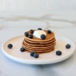 a stack of cottage cheese pancakes with yogurt and blueberries