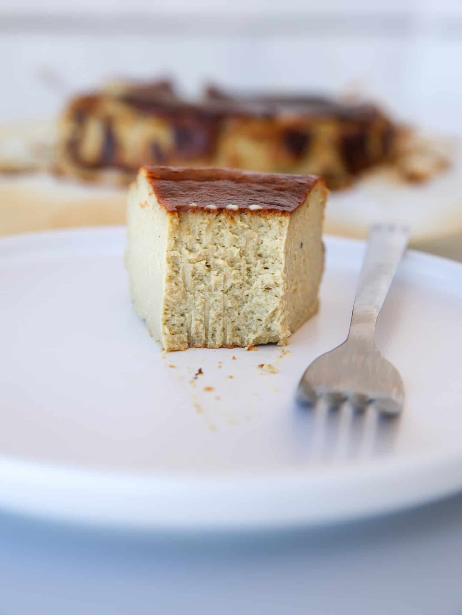 Burnt Pistachio Cheesecake with a fork on a white plate