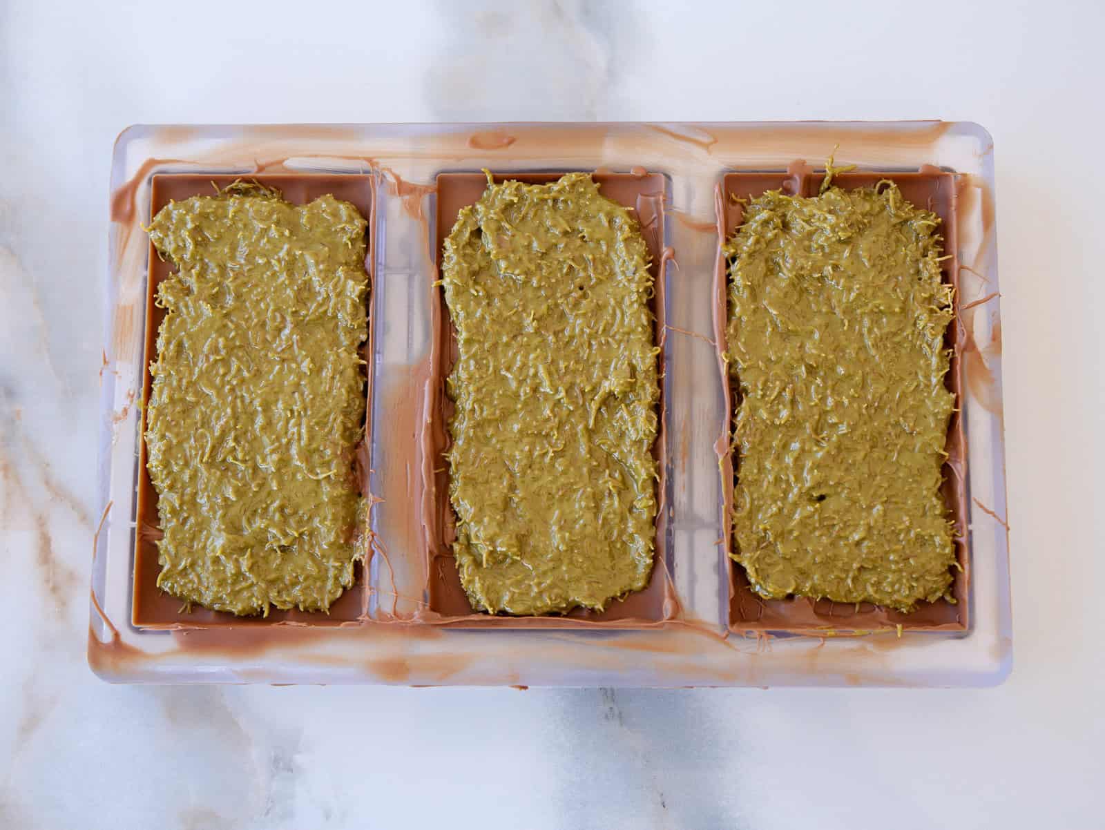 chocolate mold filled with pistachio-kataifi mixure