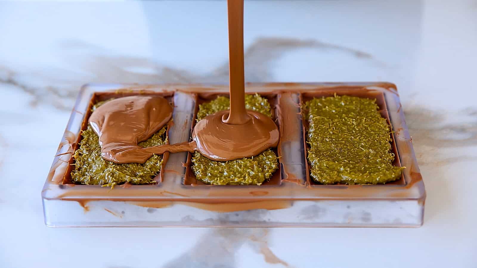 poring melted milk chocolate over kanfeh filling