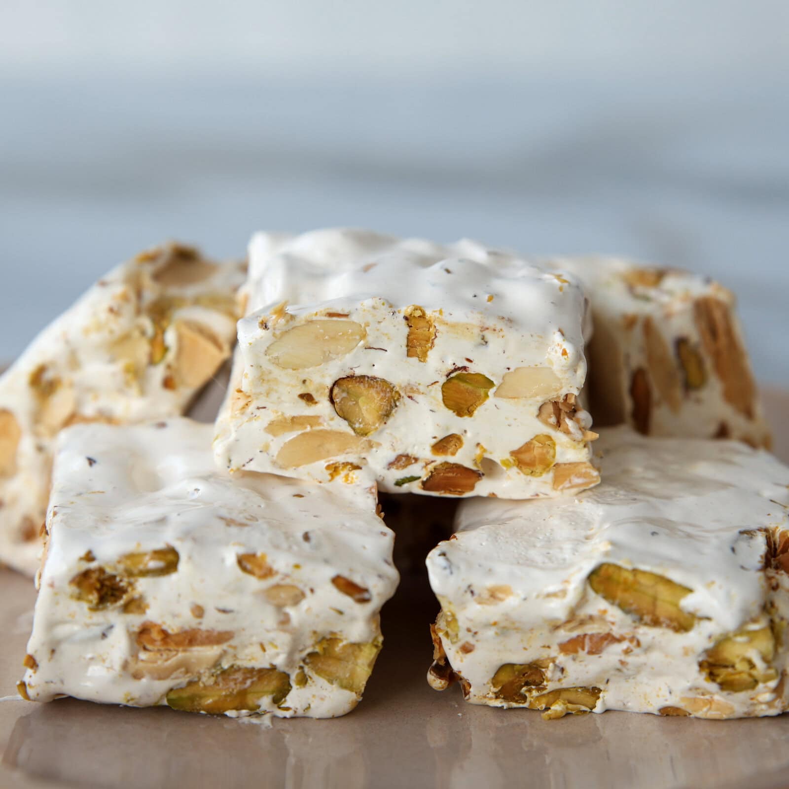 a few pieces of homemade nougat with pistachios and almonds on a plate