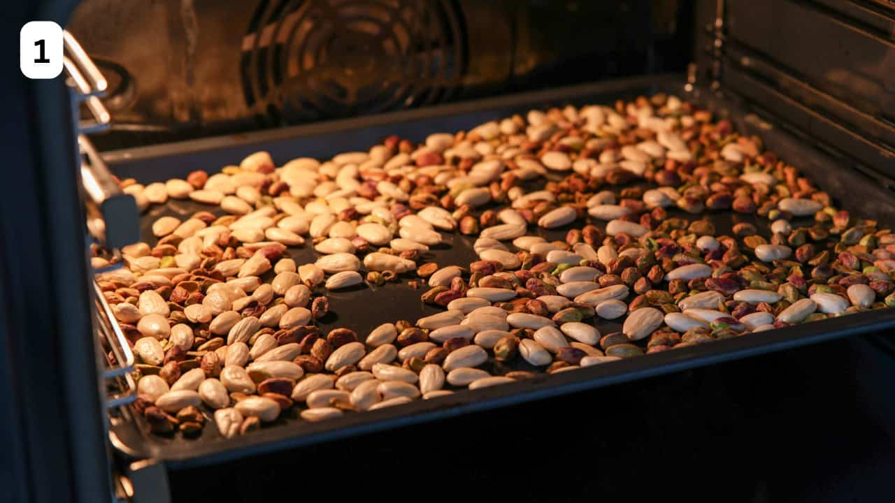 almonds and pistachio in a baking tray are roasting in the oven