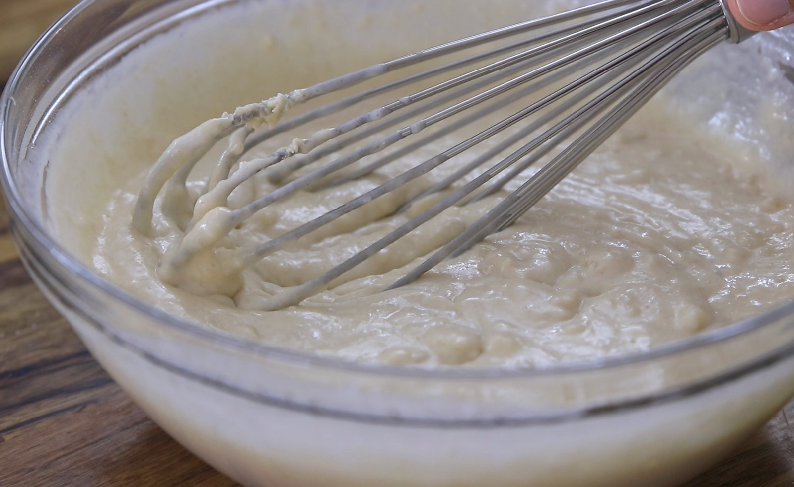 adding water and other ingredients to pancake batter