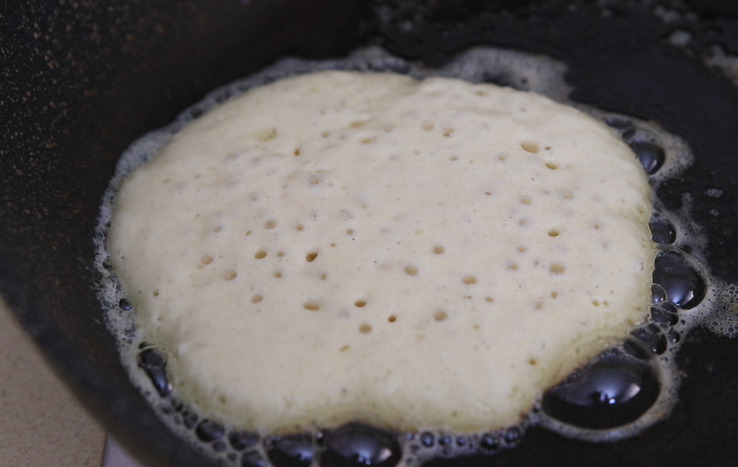 cooking pancakes until bubbles form