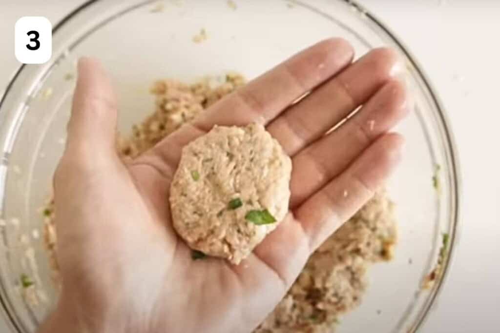 raw tuna patty formed in a hand.