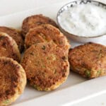 Tuna patties on a white plate along side with white dipping sauce