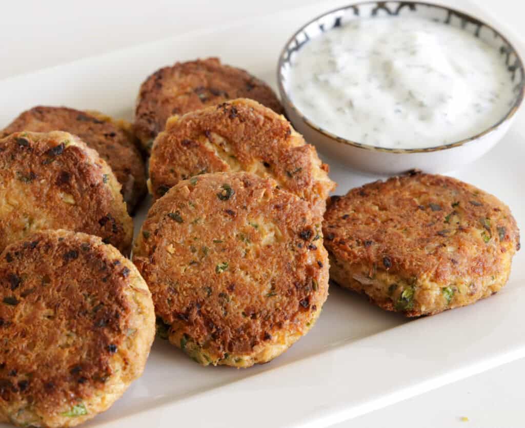 tuna patties on a platter next to dipping sauce.