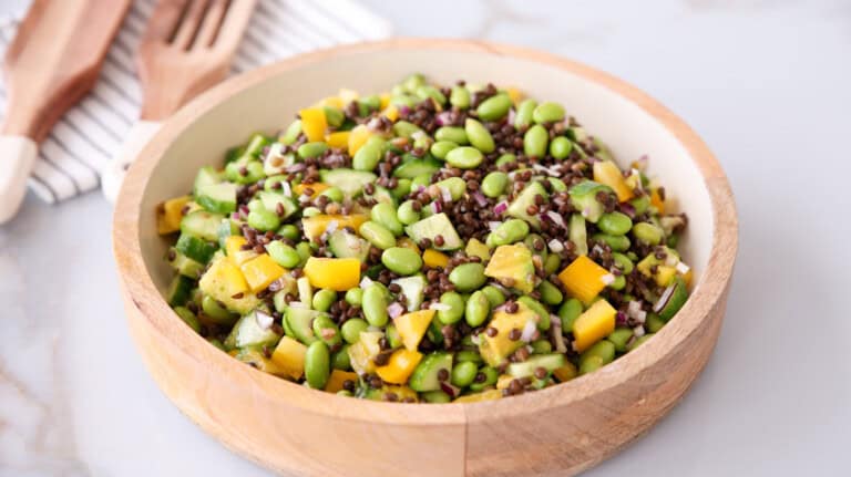 a large bowl of edamame salad with black lentils