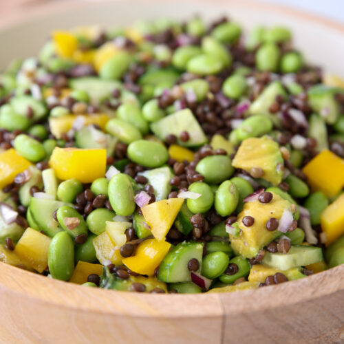 A bowl of salad with edamame, black lentils and vegetables