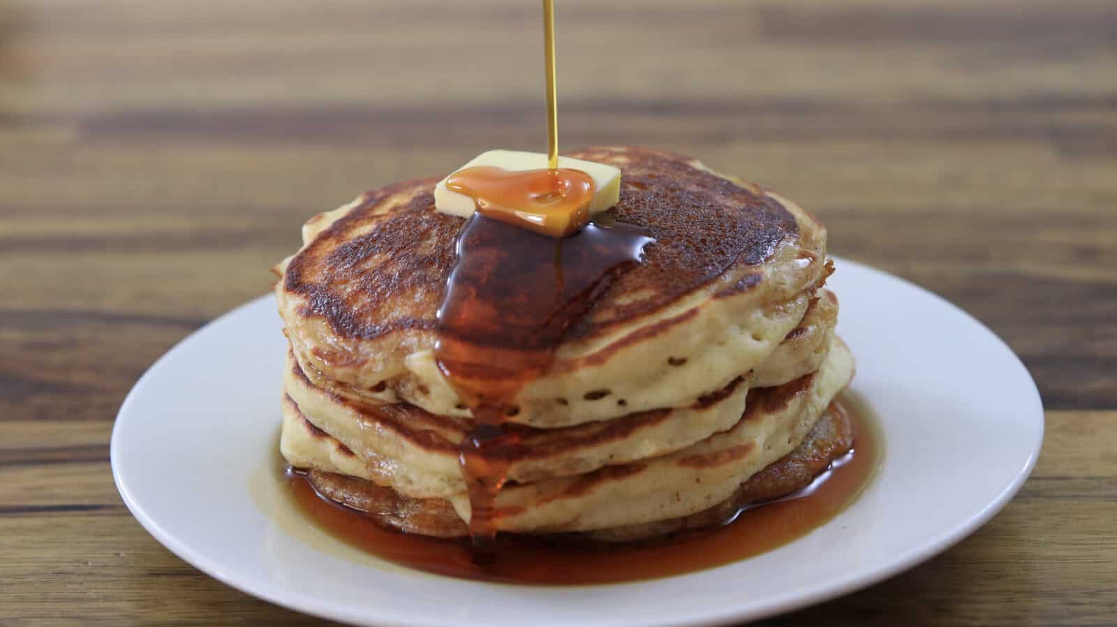 4 fluffy pancakes with a drizzle of maple syrup