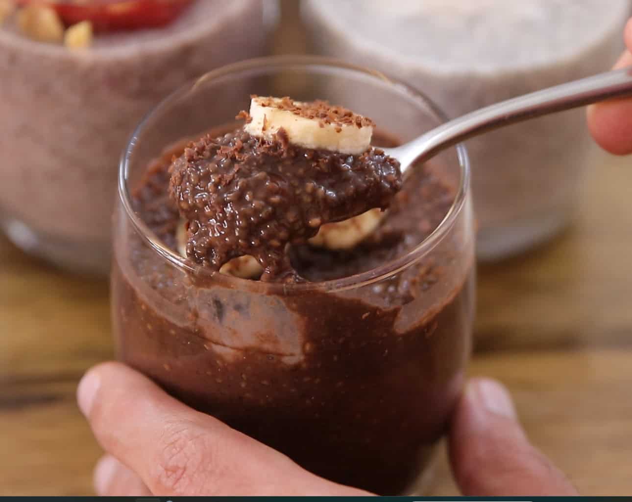 a teaspoon goes into a creamy glass of chocolate chia pudding 