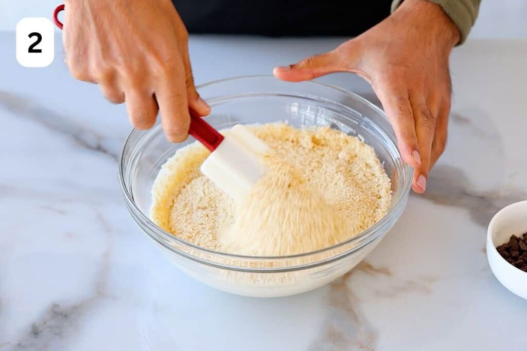 mixing dry ingredients in a bowl with spatula.