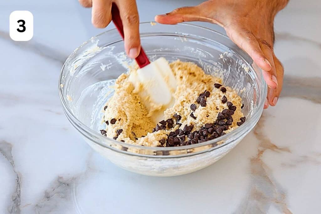 folding chocolate chips into the cookie dough.