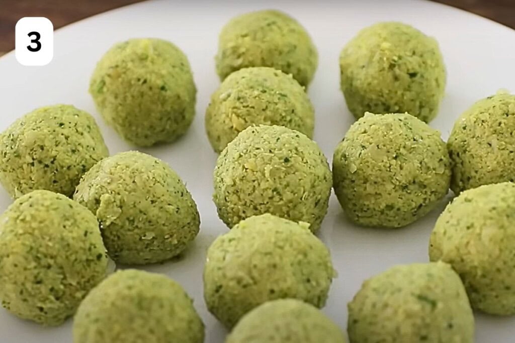 raw falafel balls on a plate.