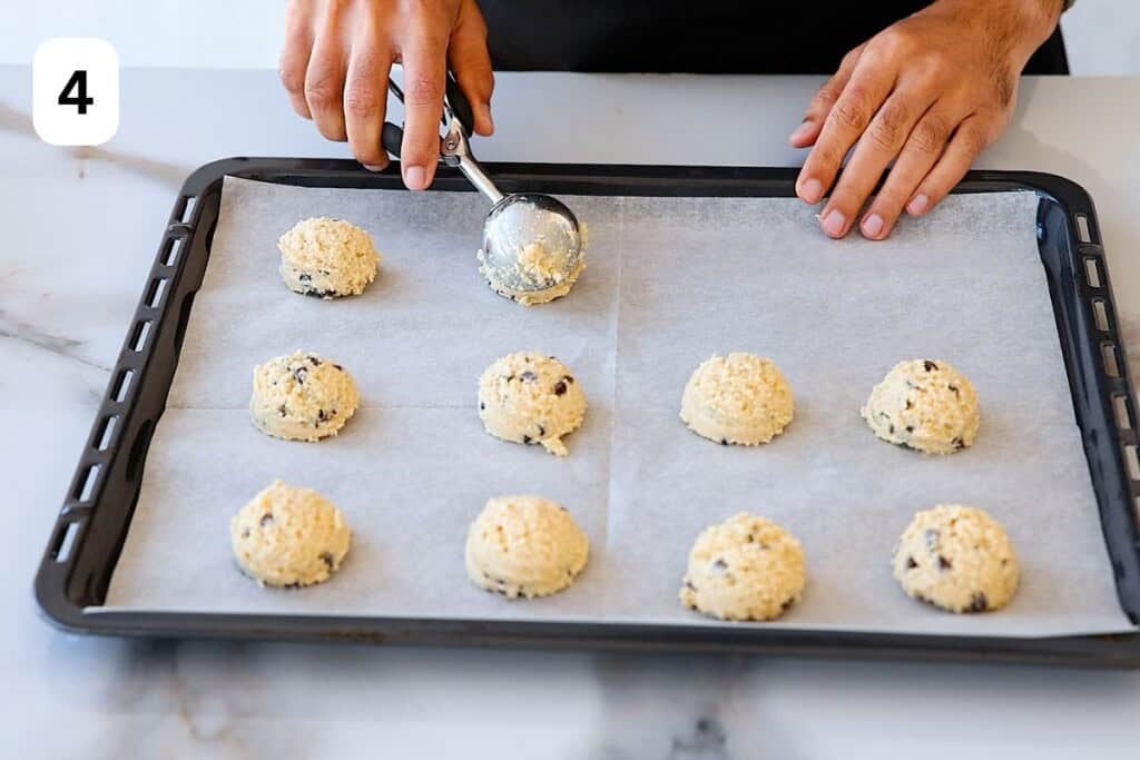 scooping cookie dough onto a baking sheet.