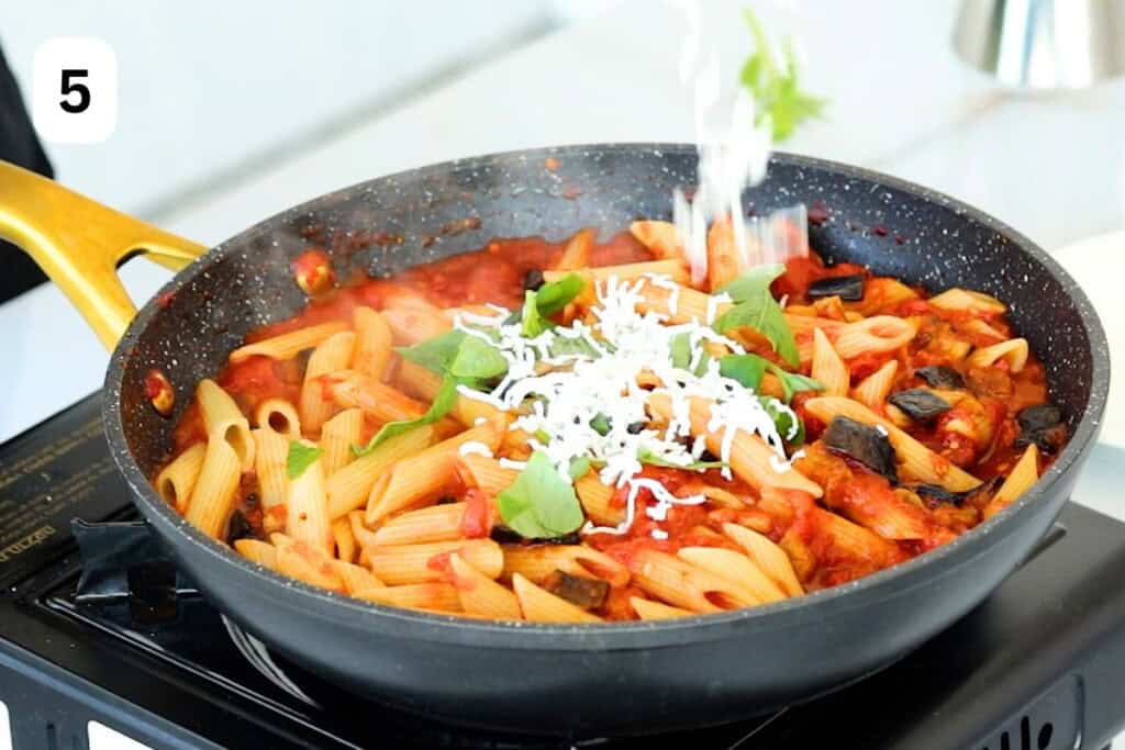 tossing ricotta salata in the skillet with pasta.